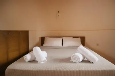 a bed with two rolls of towels on it at Wuthering Mill in Symi