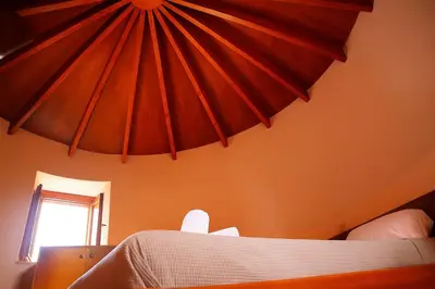 a bedroom with a bed with orange walls and a window at Wuthering Mill in Symi