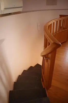 a stairway with a wooden railing and a stair case at Wuthering Mill in Symi