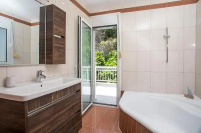 a bathroom with a sink and a tub and a window at Palmtrees Apartments in Afantou