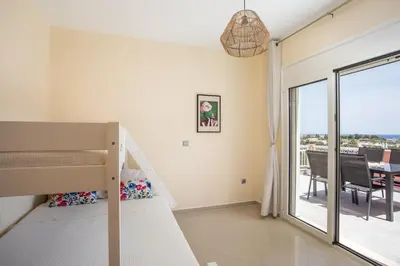 a bedroom with a bunk bed and a balcony at Palmtrees Apartments in Afantou