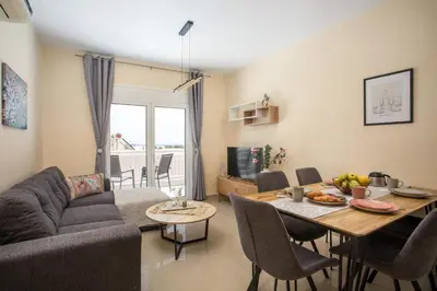 a living room with a table and a couch at Palmtrees Apartments in Afantou