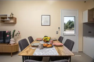 a dining room table with a bowl of fruit on it at Palmtrees Apartments in Afantou