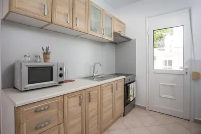 a kitchen with a microwave and a sink at Palmtrees Apartments in Afantou