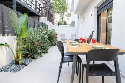 an outdoor dining room with a wooden table and chairs at NiMar luxury city villa with jacuzzi in Rhodes Town