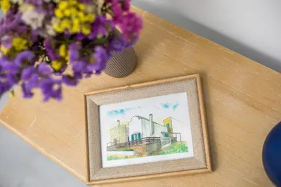 a picture frame on a table with a vase of flowers at Villa Milla in Gennadi