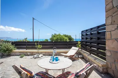 a patio with a table and chairs on a roof at Villa Milla in Gennadi