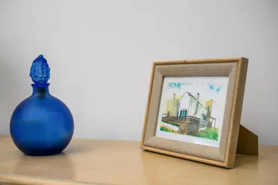 a blue vase next to a picture frame on a table at Villa Milla in Gennadi