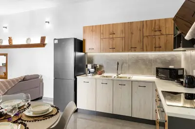 a kitchen with wooden cabinets and a stainless steel refrigerator at VaSteka House 2 in Haraki