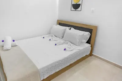 a bed with white sheets and pillows in a room at VaSteka House 2 in Haraki