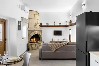 a living room with a couch and a fireplace at VaSteka House 2 in Haraki