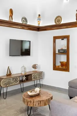 a living room with a table and a mirror at VaSteka House 2 in Haraki