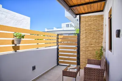 a balcony with a wooden fence and a table and chairs at VaSteka House 2 in Haraki