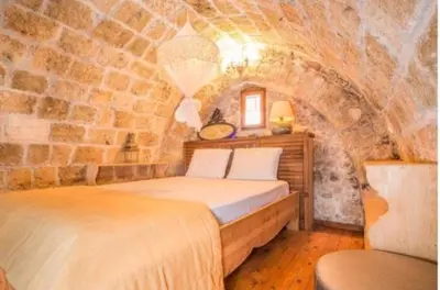 a bedroom with a bed in a stone wall at St John house Castle City in Rhodes Town
