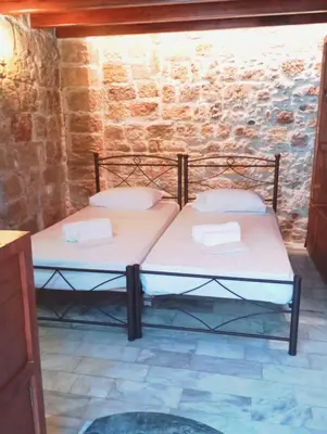 two beds in a room with a stone wall at St John house Castle City in Rhodes Town