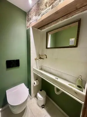 a green bathroom with a toilet and a sink at St John house Castle City in Rhodes Town
