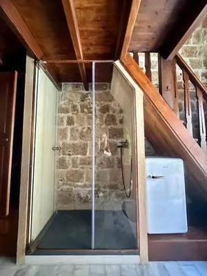 a shower in a room with a stone wall at St John house Castle City in Rhodes Town