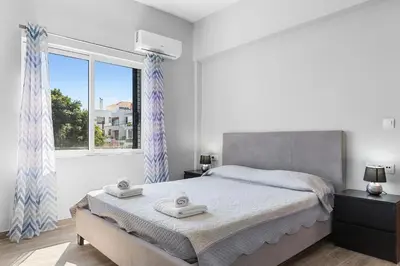 a bedroom with a bed and a large window at City Central Appartment in Rhodes Town