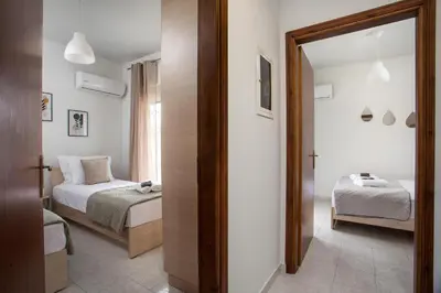 a bedroom with two beds and a mirror at Casa Platoni in Apolakkiá