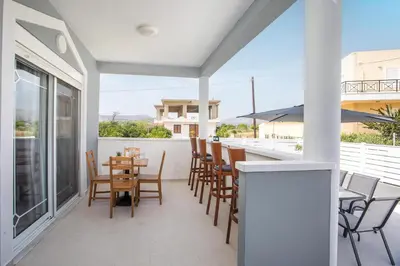 a patio with chairs and a table on a balcony at Casa Platoni in Apolakkiá