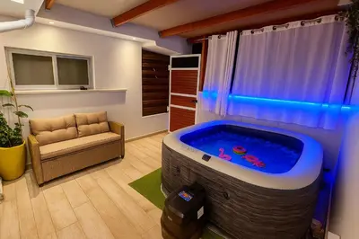 a room with a large tub with a couch and a chair at My Summerhouse with jacuzzi in Kremasti