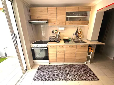 a small kitchen with wooden cabinets and a sink at My Summerhouse with jacuzzi in Kremasti