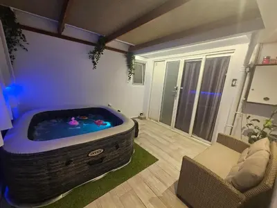 a hot tub in a living room with a couch and a chair at My Summerhouse with jacuzzi in Kremasti