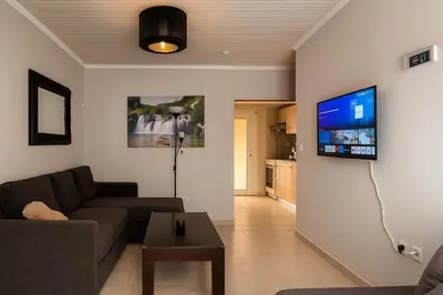 a living room with a couch and a tv on a wall at My Summerhouse with jacuzzi in Kremasti