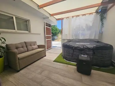 a room with a bed and a couch and a window at My Summerhouse with jacuzzi in Kremasti