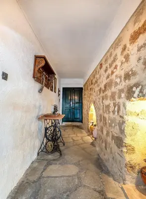 a hallway with a table and a stone wall at Levent Traditional Villa Rhodes Castle in Rhodes Town