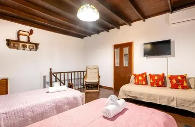 a room with two beds and a tv and a chair at Levent Traditional Villa Rhodes Castle in Rhodes Town