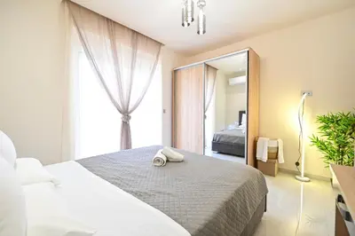 a bedroom with a bed and a large window at Harmony Studio Apartment in Ialyssos