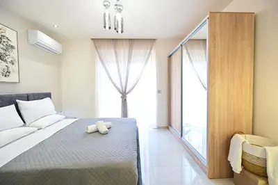 a bedroom with a bed and a large window at Harmony Studio Apartment in Ialyssos