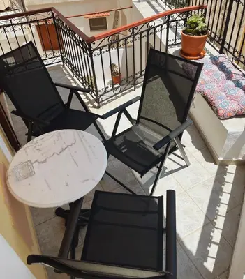 a group of chairs and a table on a balcony at Margo Traditional House in Symi
