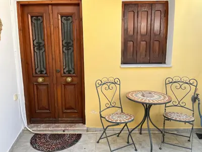 two chairs and a table in front of a door at Margo Traditional House in Symi
