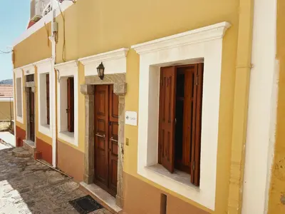 a row of doors on the side of a building at Margo Traditional House in Symi