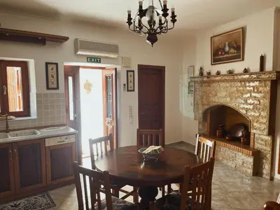 a dining room with a table and a fireplace at Margo Traditional House in Symi