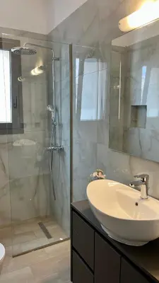 a bathroom with a sink and a glass shower at Apartamento Elegante de Chris in Rhodes Town