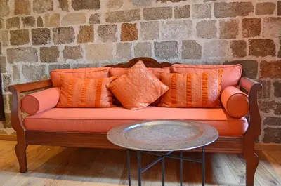 an orange couch with orange pillows and a table at Hotel Ellique in Rhodes Town