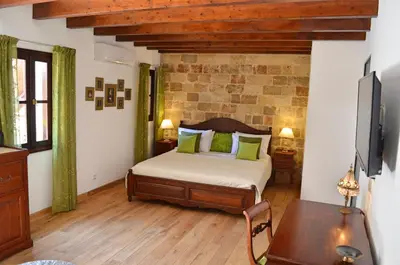 a bedroom with a bed and a table in it at Hotel Ellique in Rhodes Town