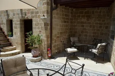 a patio with chairs and a table in a building at Hotel Ellique in Rhodes Town