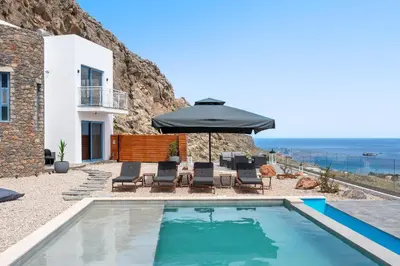 a villa with a swimming pool and an umbrella at Aitheria Lindos Villa in Líndos