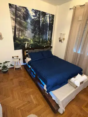 a bedroom with a bed with a painting on the wall at Ciel Apartment in Rhodes Town