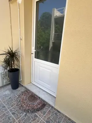 a white door on a house with a potted plant at Ciel Apartment in Rhodes Town