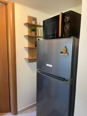 a refrigerator with a microwave on top of it at Ciel Apartment in Rhodes Town