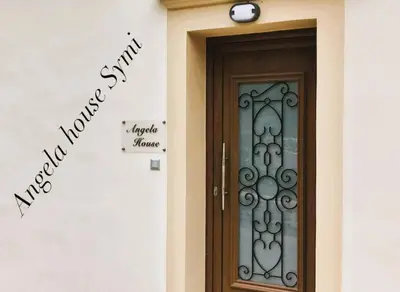 a door to a house with a sign on the wall at Angela House in Symi