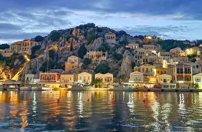 a small town on the shore of a body of water at Angela House in Symi