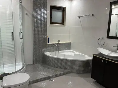 a bathroom with a tub and a toilet and a sink at Angela House in Symi