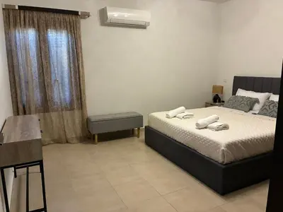 a bedroom with a bed and a chair and a window at Angela House in Symi