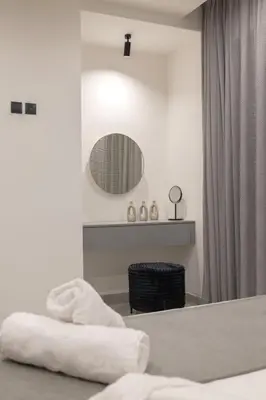 a white room with a bed and a mirror at Villa Viventia with Heated Pool in Afantou